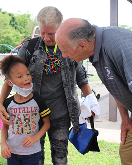 John leaning down listening to young girl speak