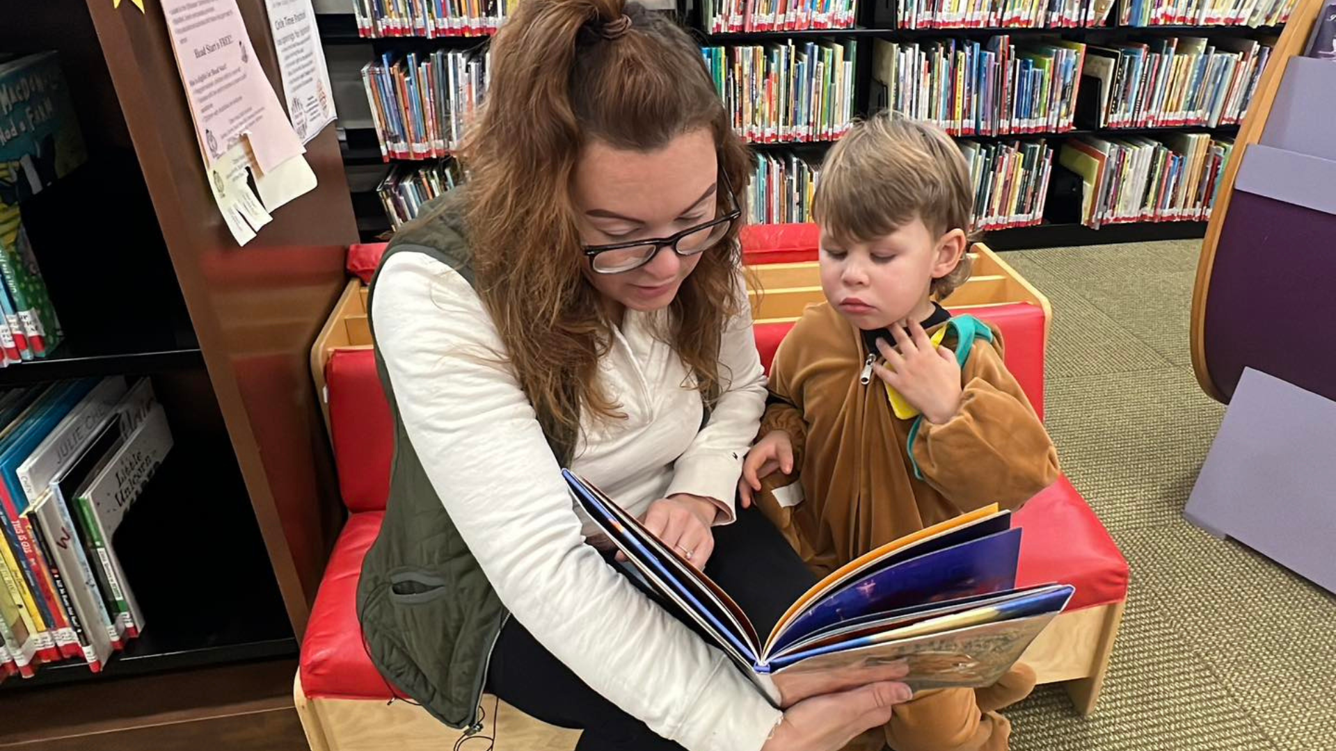 Mother reading to son in Scooby Doo costume