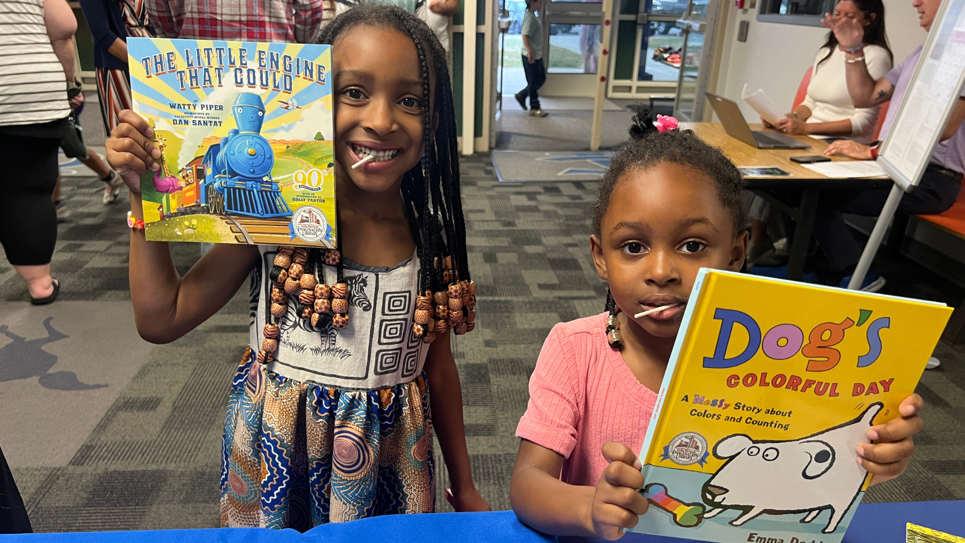 Two girls holding up their new books