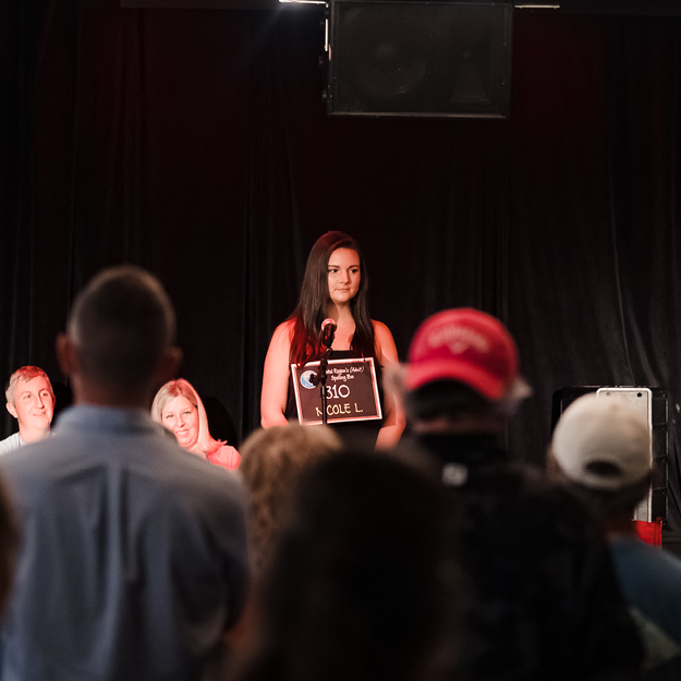 Speller standing on stage looking over crowd