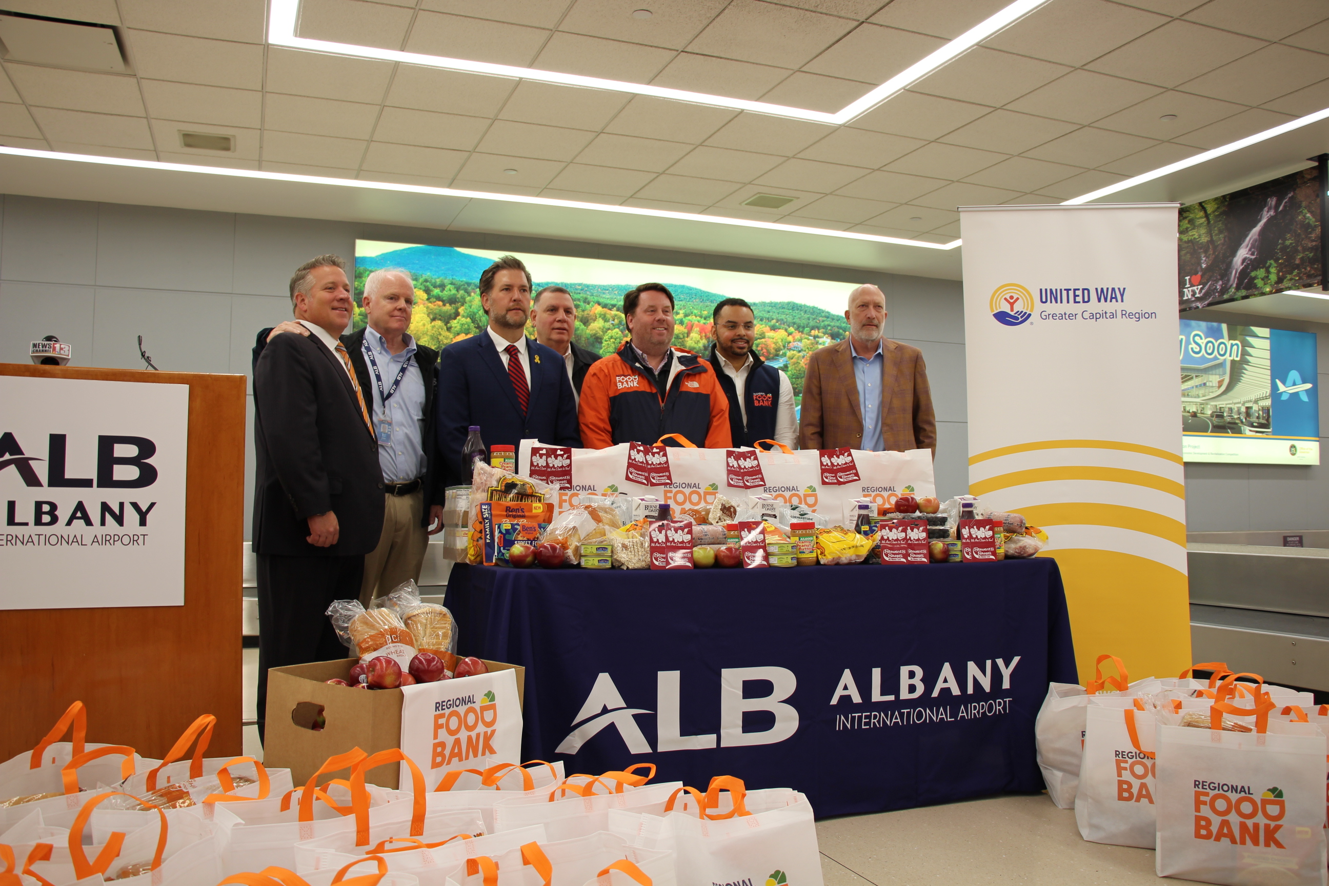 Speakers behind the table with Foodbank bags of food and giftcards