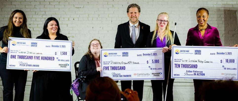 Power Pitch winners holding giant checks