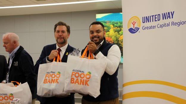 Michael Aaron Poindexter and Peter Gannon holding Food Bank bags filled with food