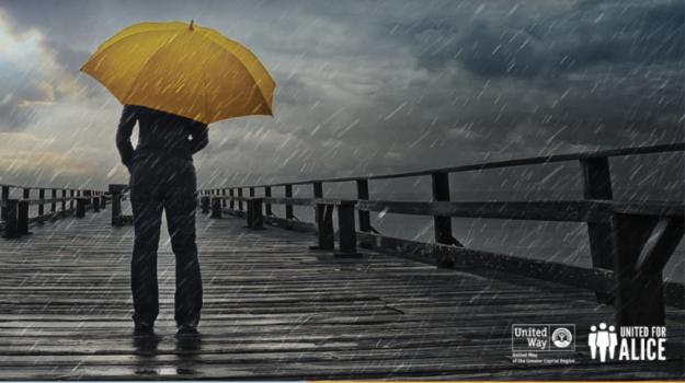 person walking on the boardwalk in the rain with yellow umbrella