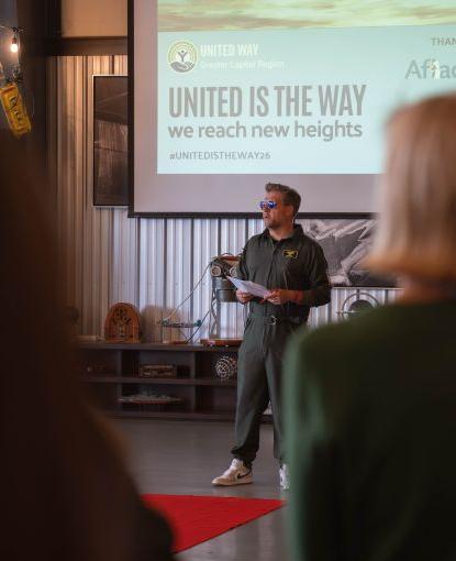 Peter in flight suit addressing the crowd