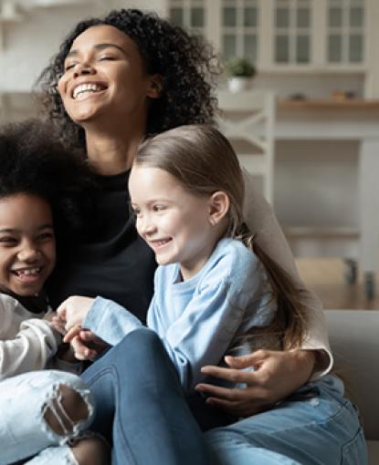 Foster family on laughing on couch