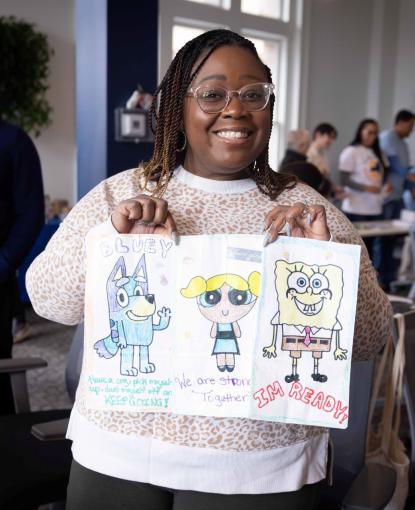 Volunteer holding up illustrated literacy bags