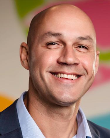 Brian Smiling against colorful wall