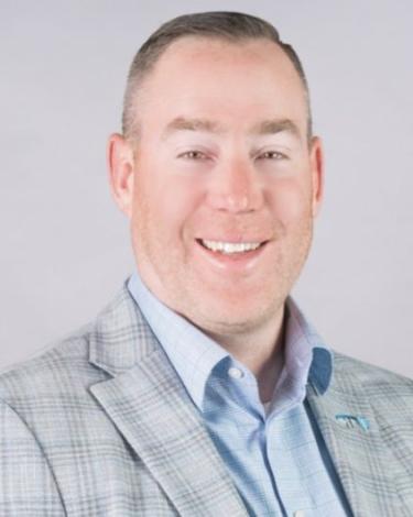 Kevin smiling in gray suit