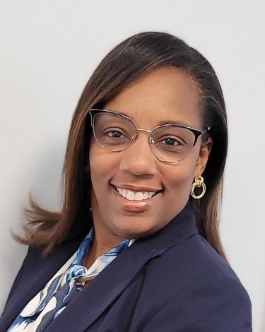 Selica Y Grant in navy suit smiling